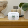 ultrafire ubco1d carbon monoxide alarm with display shown on a wooden sideboard next to candles and a plant